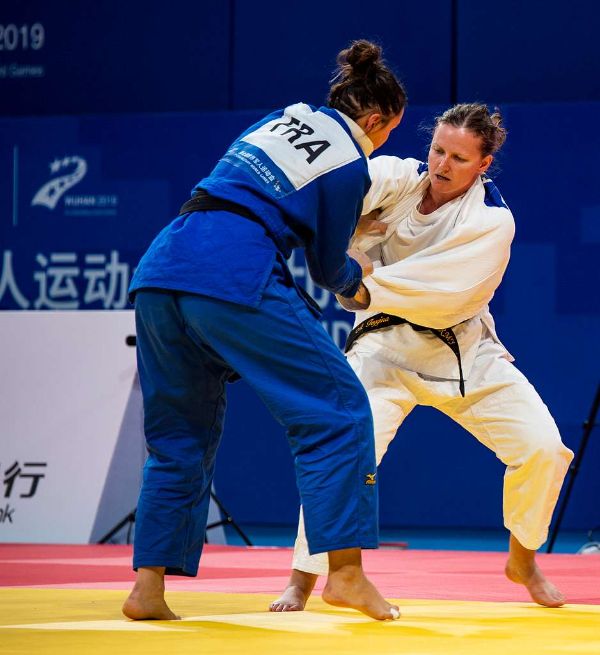 Two judoka in blue and white judogi establishing grips